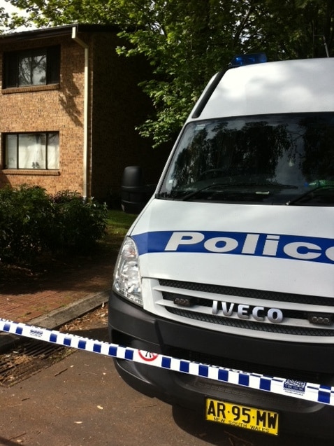 Forensic police set up a crime scene outside a unit block in Platt Street, Waratah.