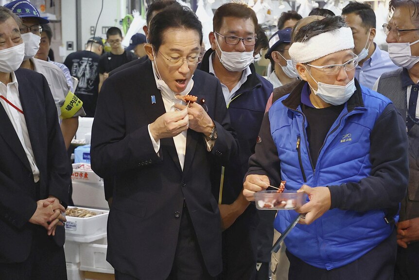 日本首相岸田文雄品尝海产品。
