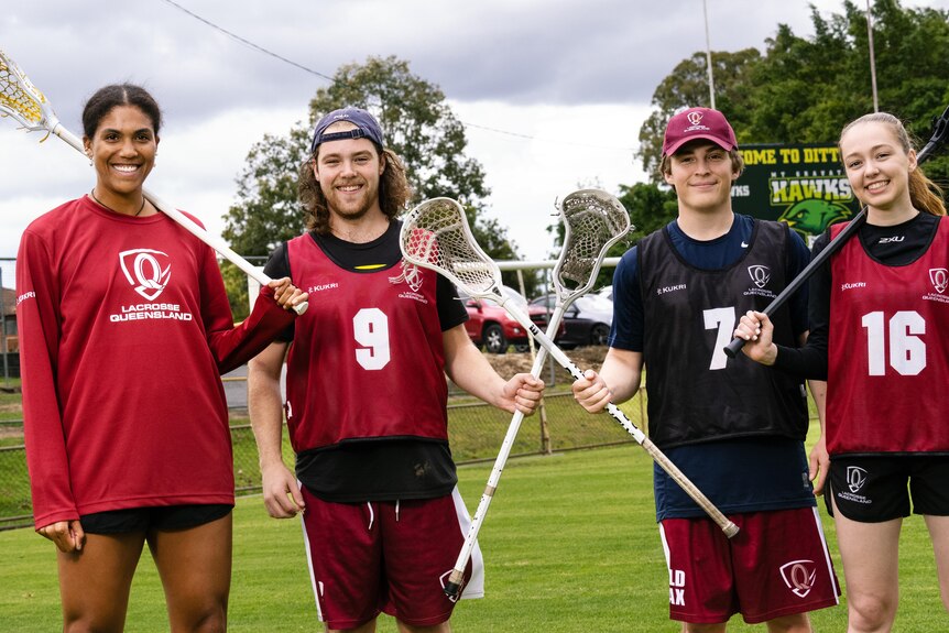 Four lacrosse players on a field.