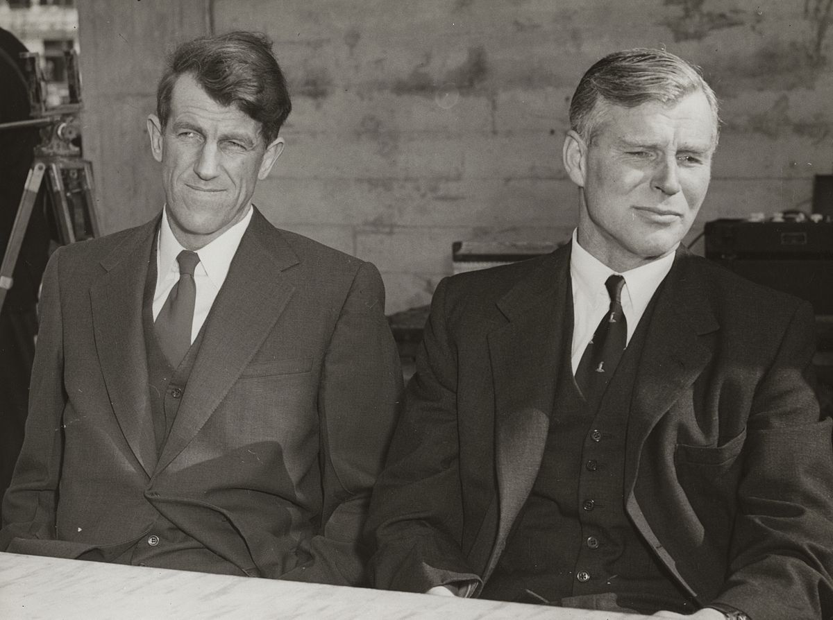 Imagem em preto e branco de Sir Edmund Hillary e Sir Vivian Fuchs, ambos parecendo sérios.
