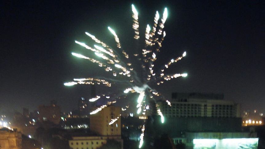 Fireworks explode over a packed Tahrir Square in Cairo
