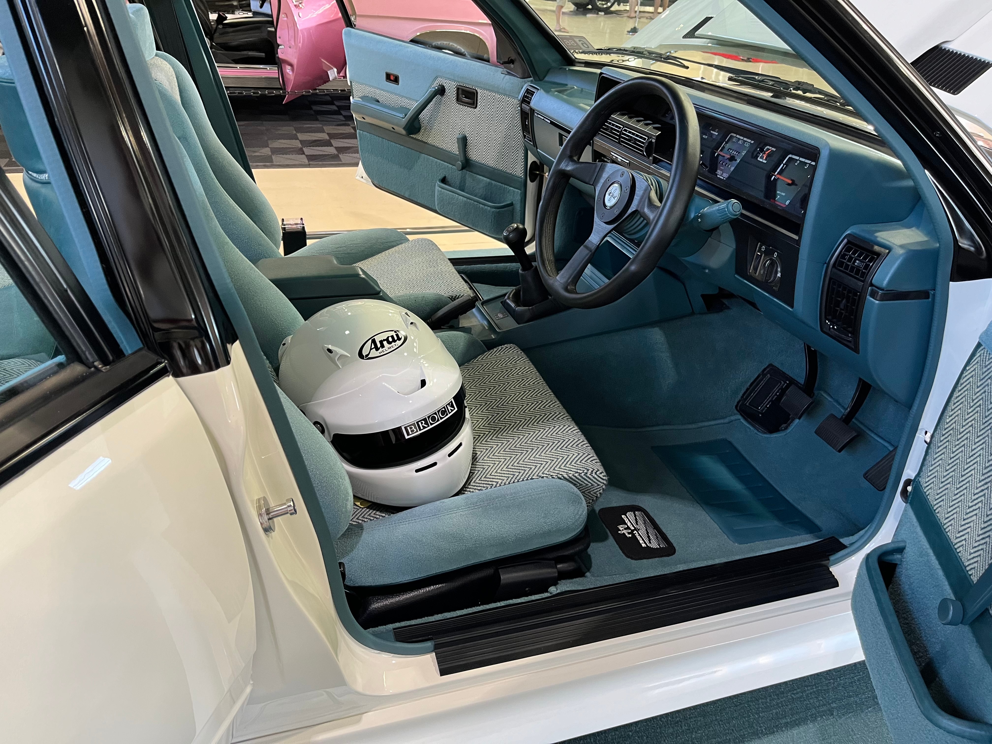 El interior de un coche con casco de carreras en el asiento del conductor.