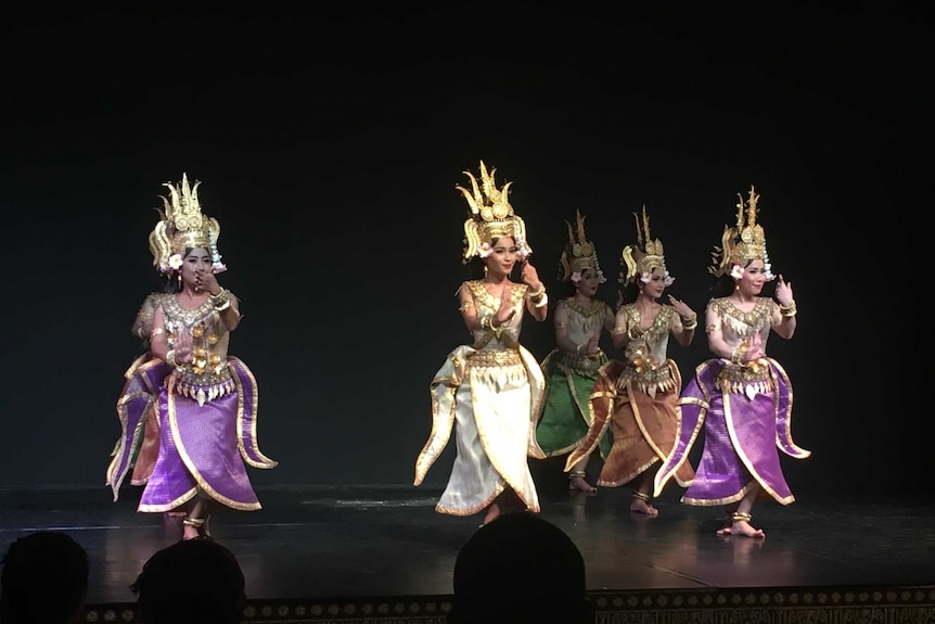 Traditional Khmer dancers perform on a stage.