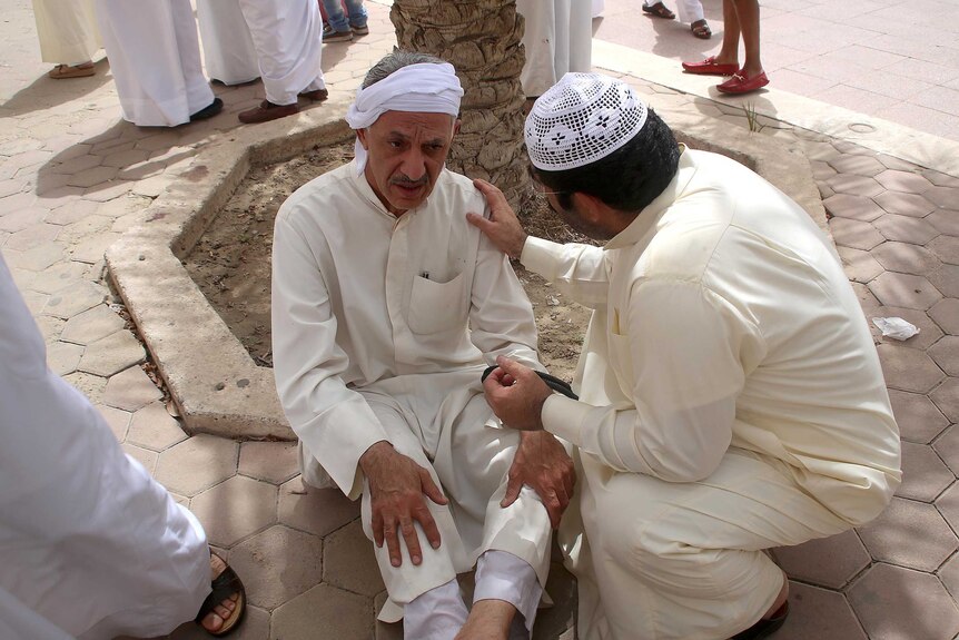 A Kuwaiti man reacts at the site of a suicide bombing