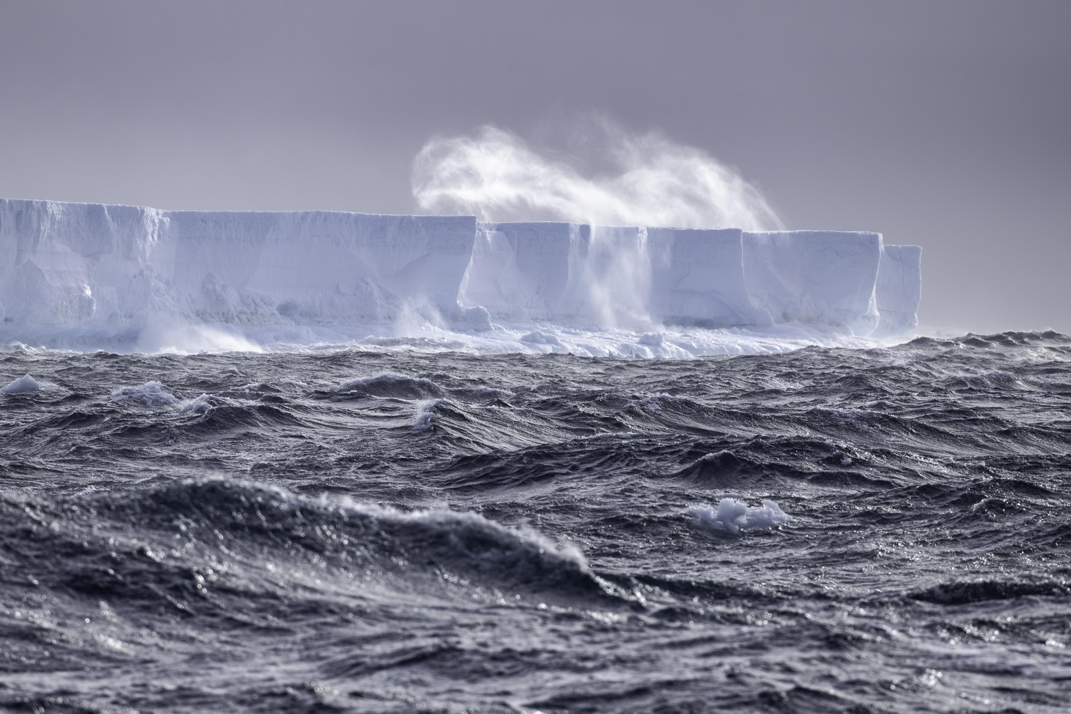Waves crash into an iceberg in the Antarctic region.