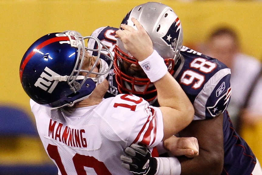 Eli Manning takes a hit whilst standing tall in the pocket.