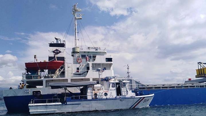 The ship MV Kudos being guarded by a Coast Guard ship.