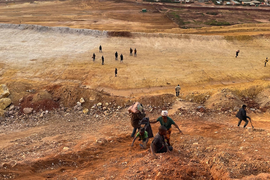 A woman and two children climb a mine.