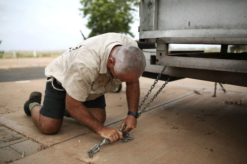 A man chains down a caravan.