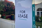 A for lease sign at a picket fence