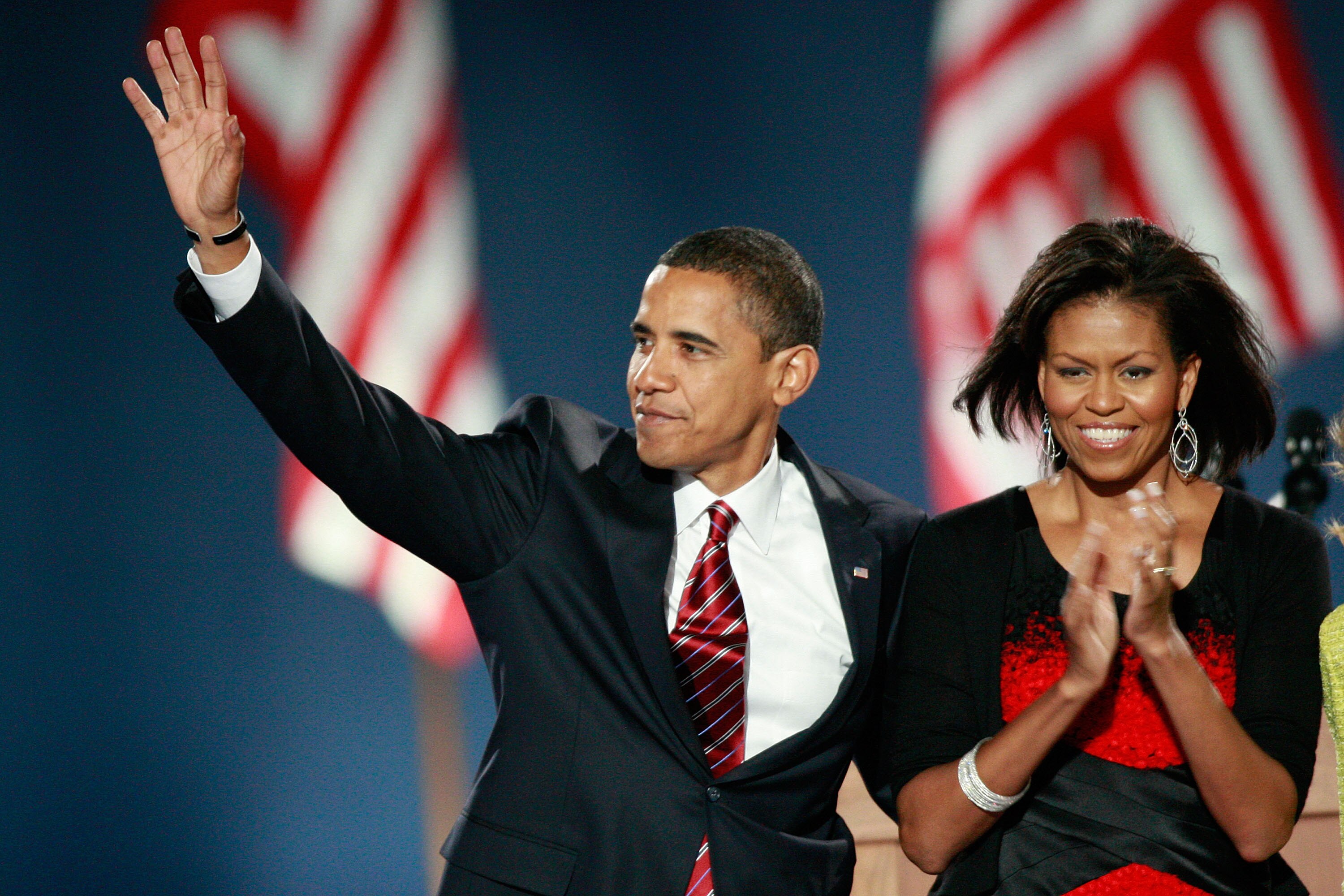 Barck Obama waves as his wife Michelle claps.
