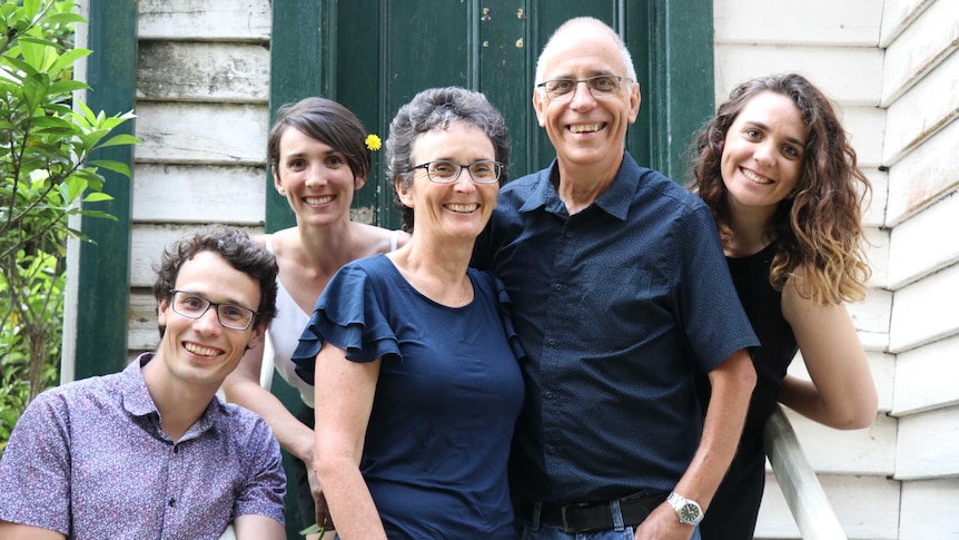 Seventh-day Adventist Paul Rankin, his wife and three adult children outside of a green and cream-coloured wooden house.