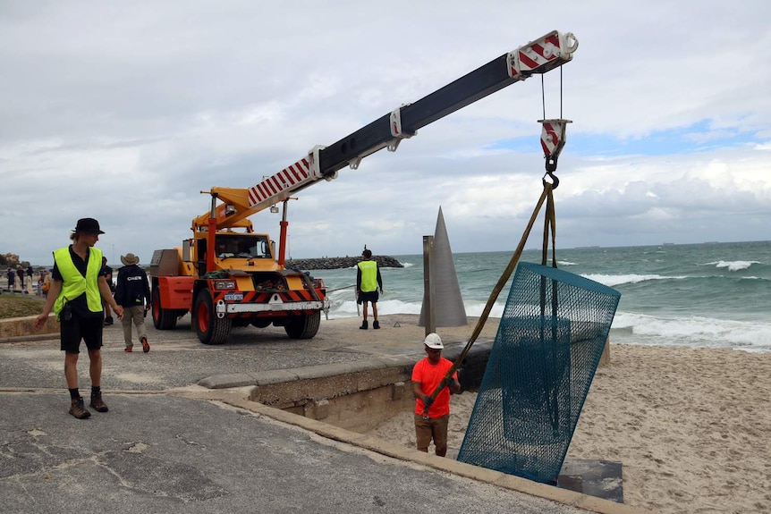 A sculpture is being removed from Cottesloe as tide rises.