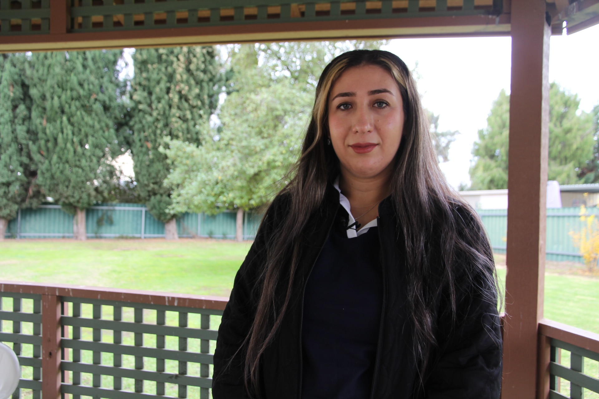 Shelan looking at the camera with trees and grass in background