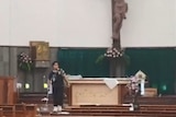 A man is seen wielding a weapon inside the church near the altar
