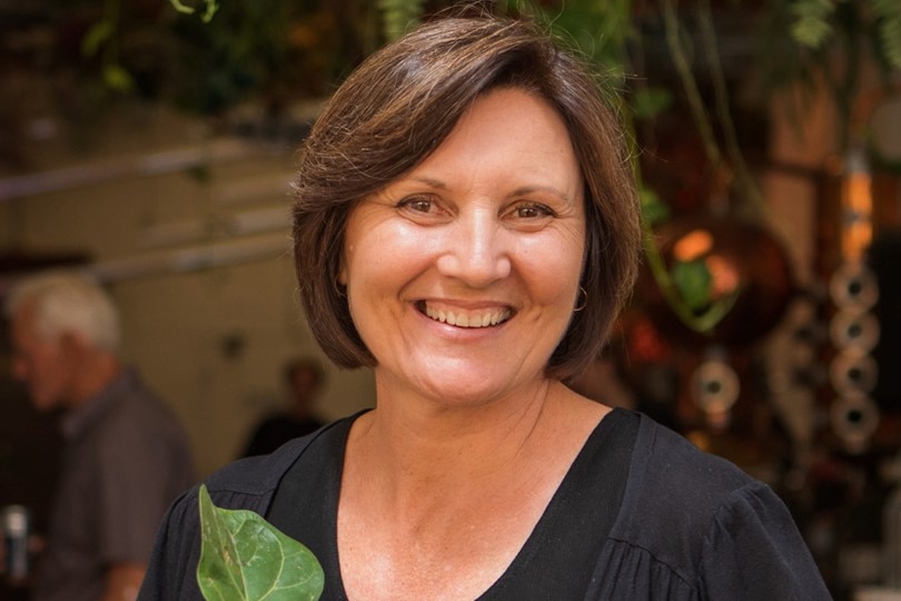 Portrait of horticulturalist Toni Salter smiling while holding a plant