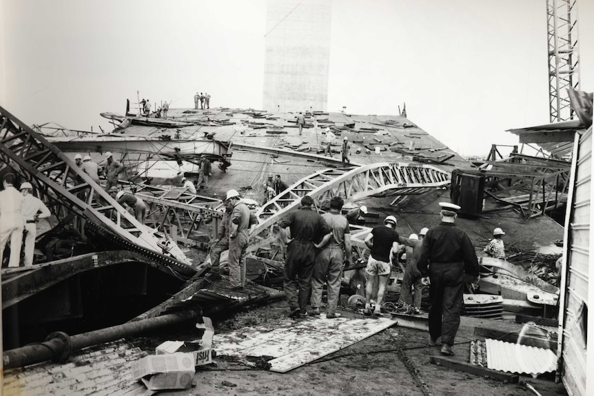 A black and white photograph of emergency workers at the scene of the collapsed West Gate Bridge in 1970.