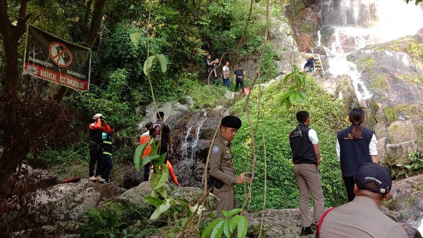 Police and rescuers retrieving the body of a tourist who fell down a waterfall.