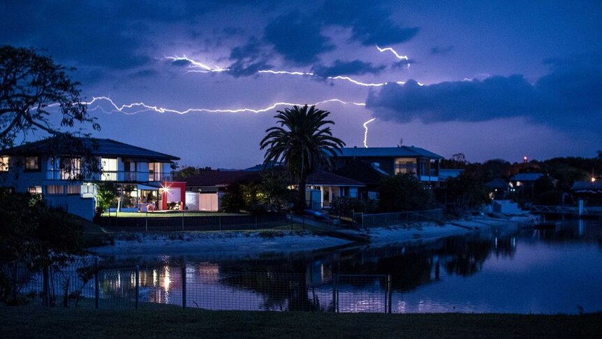 Lightning strikes over homes at night on the Gold Coast.