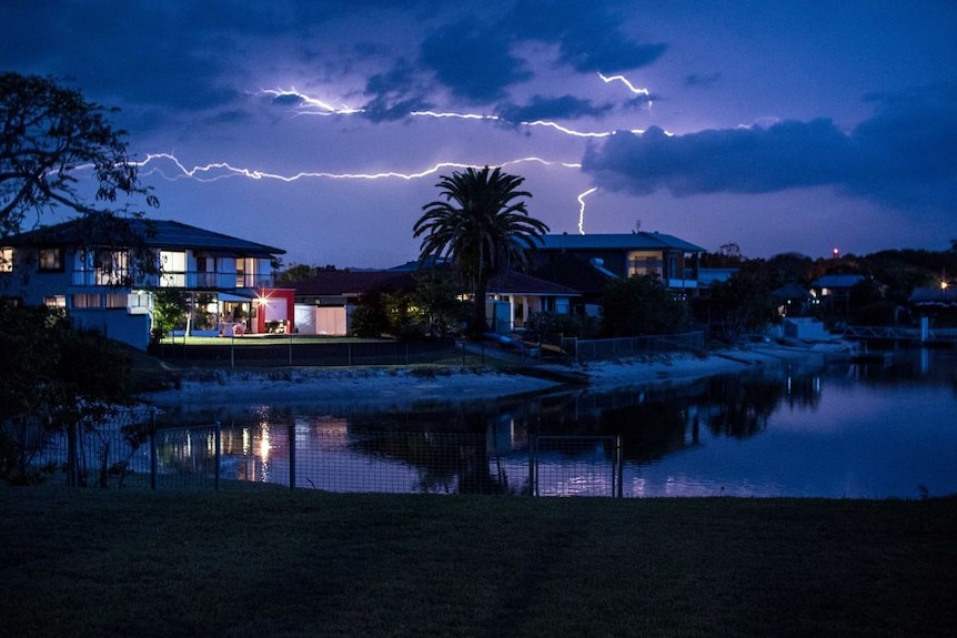 Lightning strikes over homes at night on the Gold Coast.