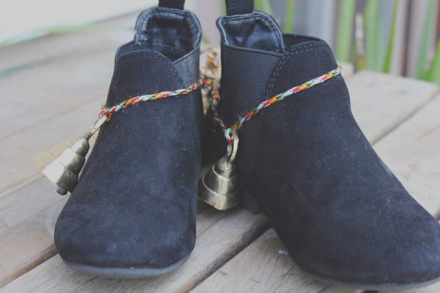 A pair of black children's boots with bells wrapped around them for a story about parenting with a disability.