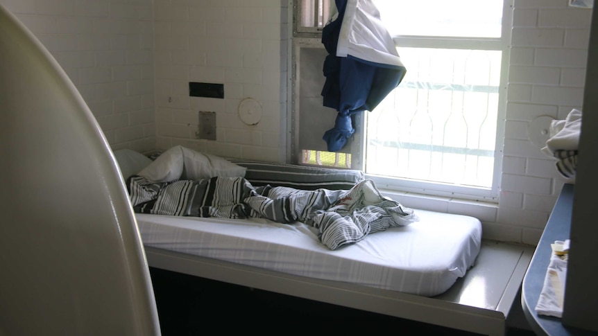 An unmade bed next to barred windows in Banksia Hill Detention Centre.