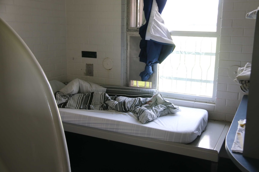 An unmade bed next to barred windows in Banksia Hill Detention Centre.