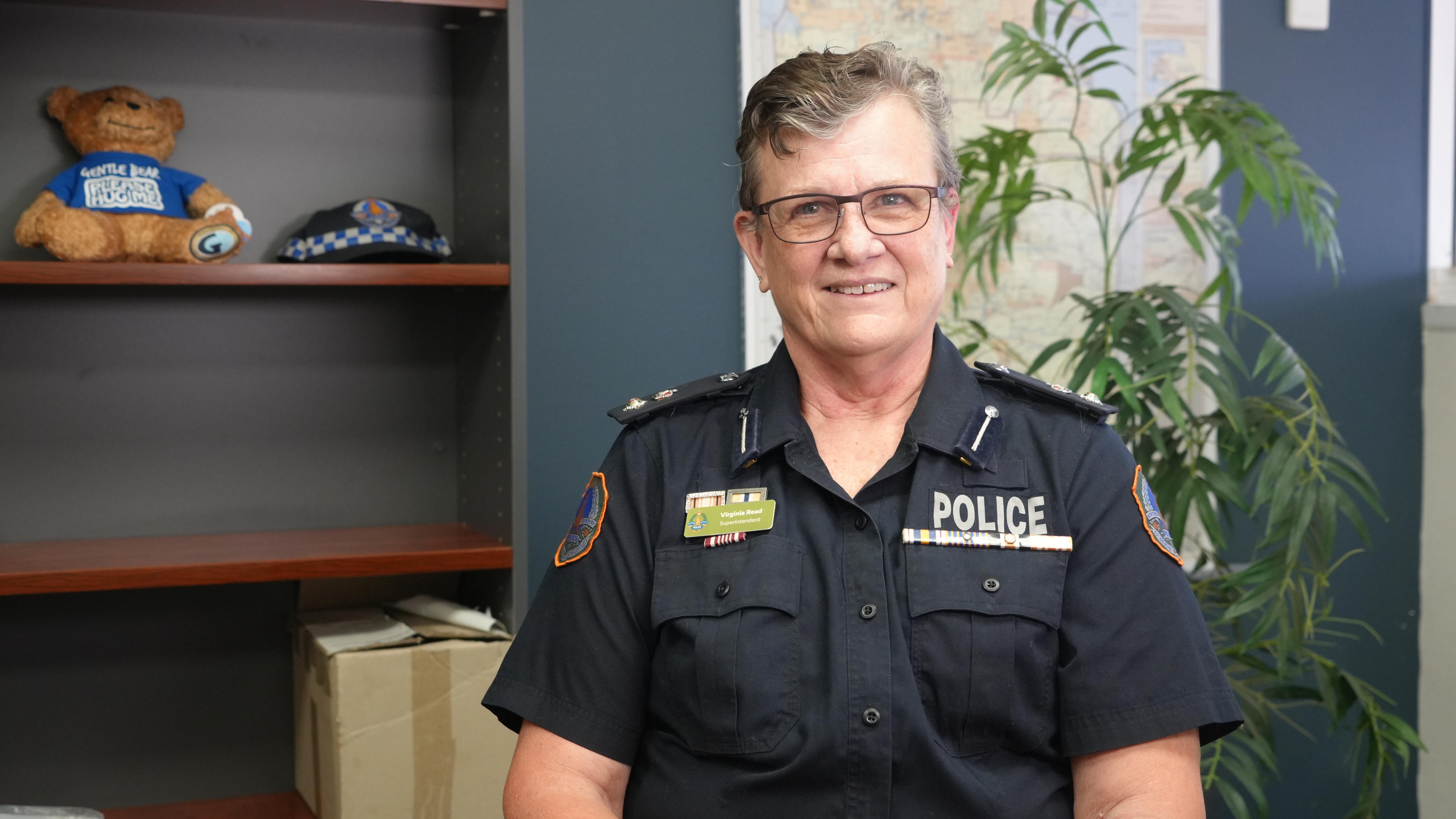 Virginia Read smiles for the camera while sitting in her office wearing her blue police uniform.