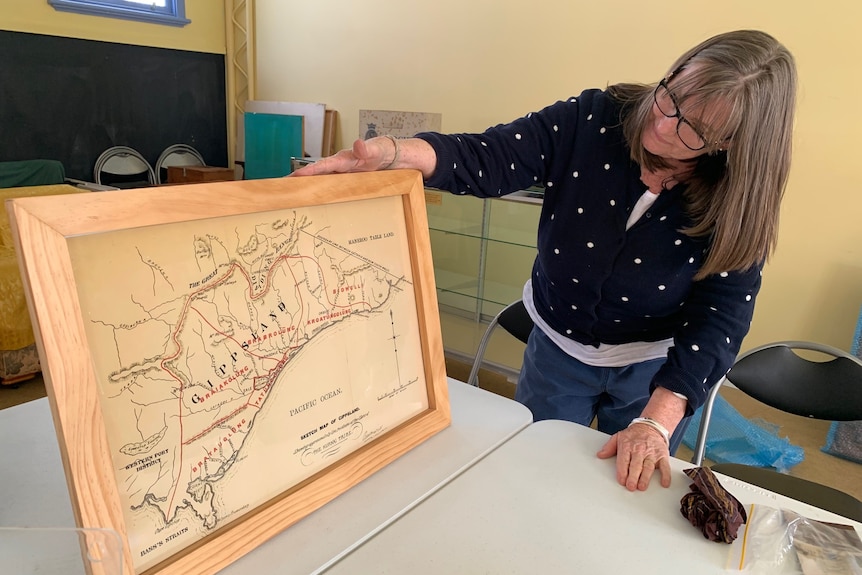 women holding fram of antique map.