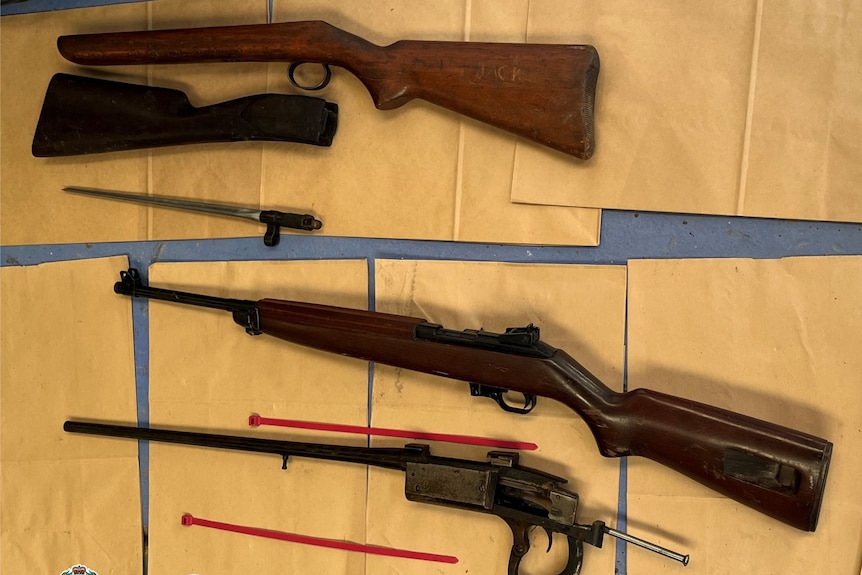 Large firearms on the floor found by police. 