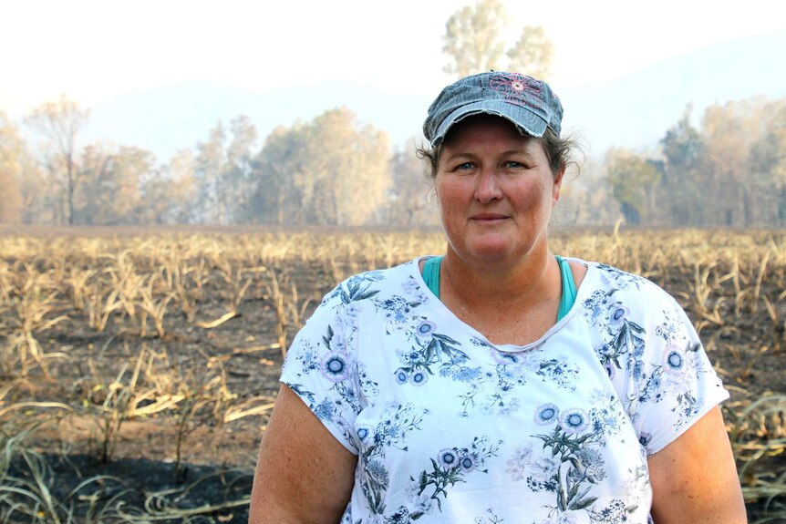 Jenny Ward stands in front of burnt paddocks.