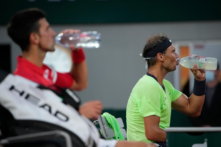 Rafael Nadal and Novak Djokovic both drink from water bottles