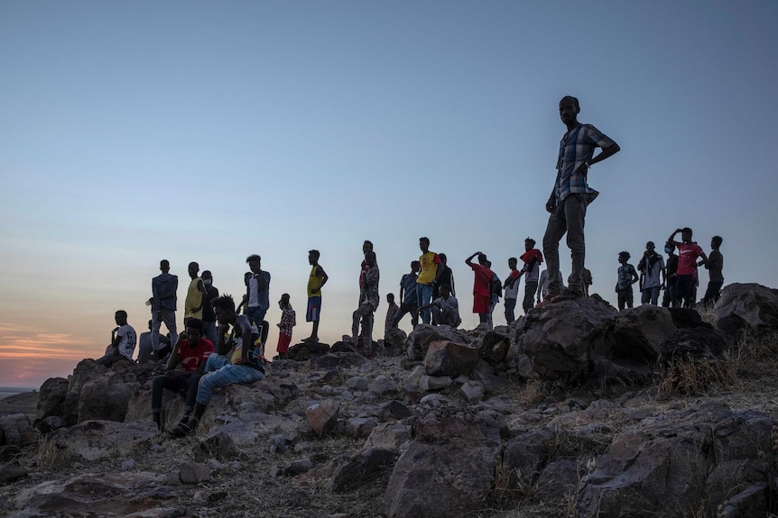 Tigrayan refugees stands on a hill in Sudan.