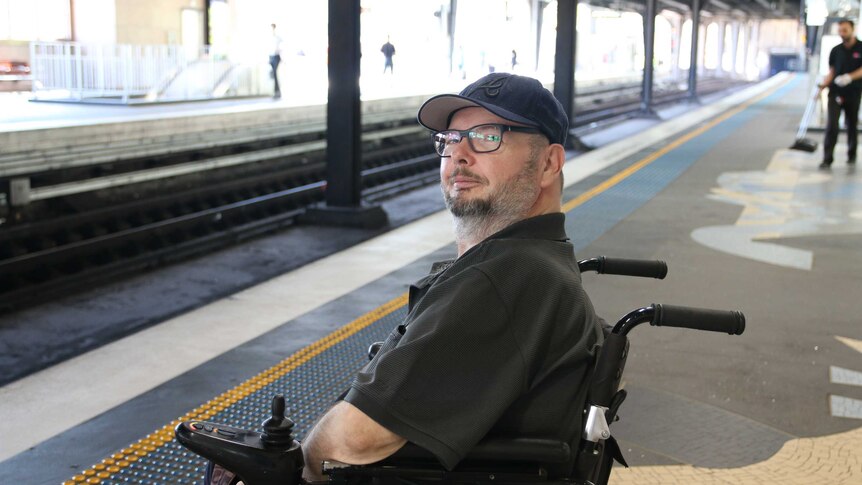 Andrew Emmerson in a wheelchair on a train platform