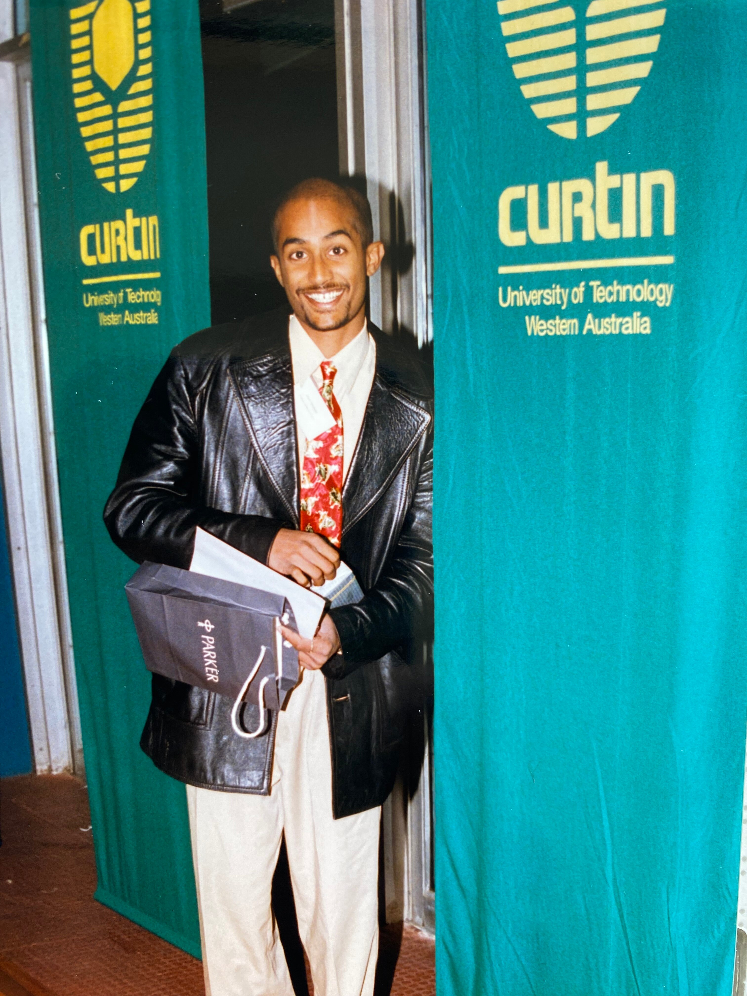 A man in a leather jacket wearing a red tie