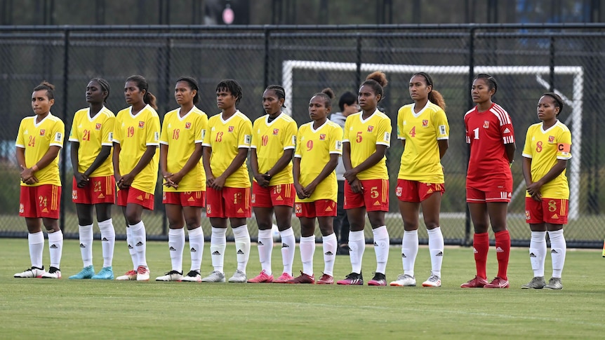 A group of female football players line up before a match