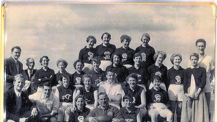 Black and white image of women in football outfits posing for a team photo