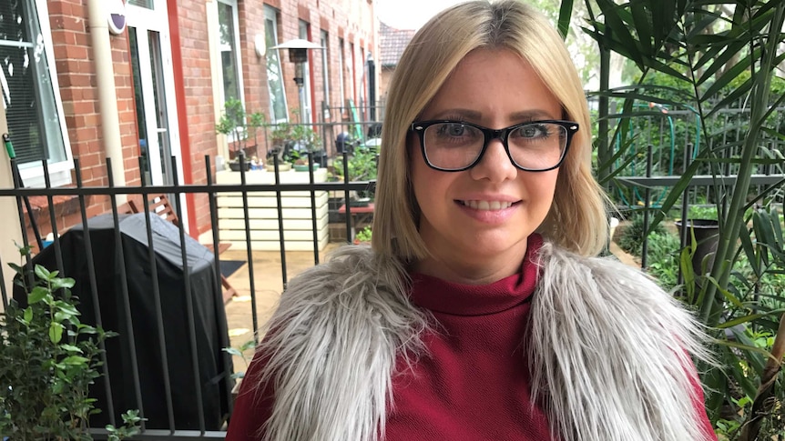 Headshot of Blonde 29 year old Briony Carnohan, wearing black frame glasses, is looking to purchase a home in Sydney.