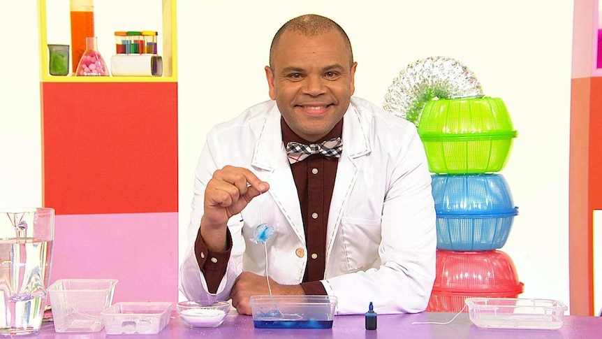 Luke on the Play School Science Time set wearing a lab coat with a craft fish in blue water