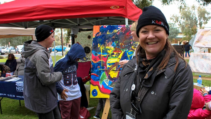 Cathy Graham from the West Darling Arts Association stands in front of a collaborative art work.