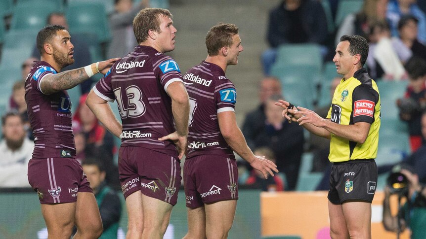 Daly Cherr-Evans speaks with referee Gerard Sutton, as his Manly teammates look on.