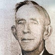 A faded black and white photo of an older gentleman om a suit.