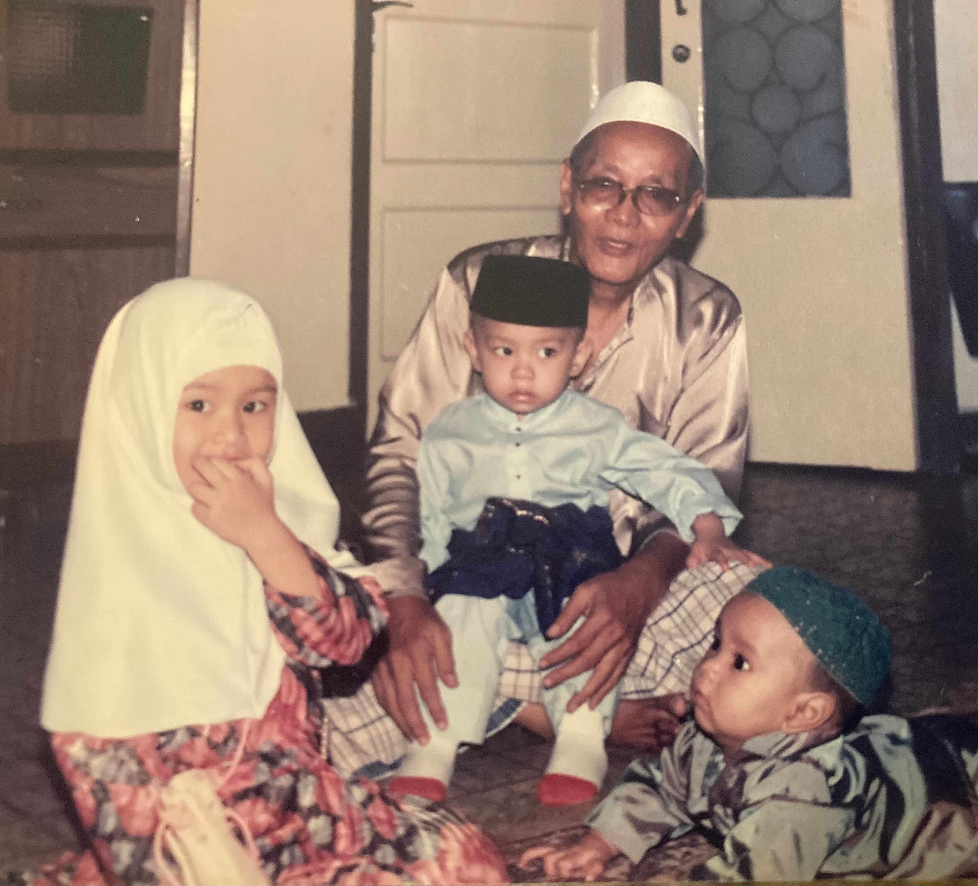 A photo of a Raidah when she was little with her brother and another family member. She and her brother are in Islamic dress 