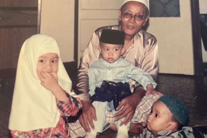 A photo of a Raidah when she was little with her brother and another family member. She and her brother are in Islamic dress 