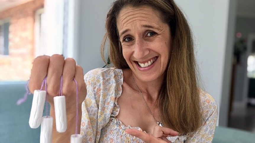 Woman with a questioning look, or look of horror, holding a bunch of clean tampons.