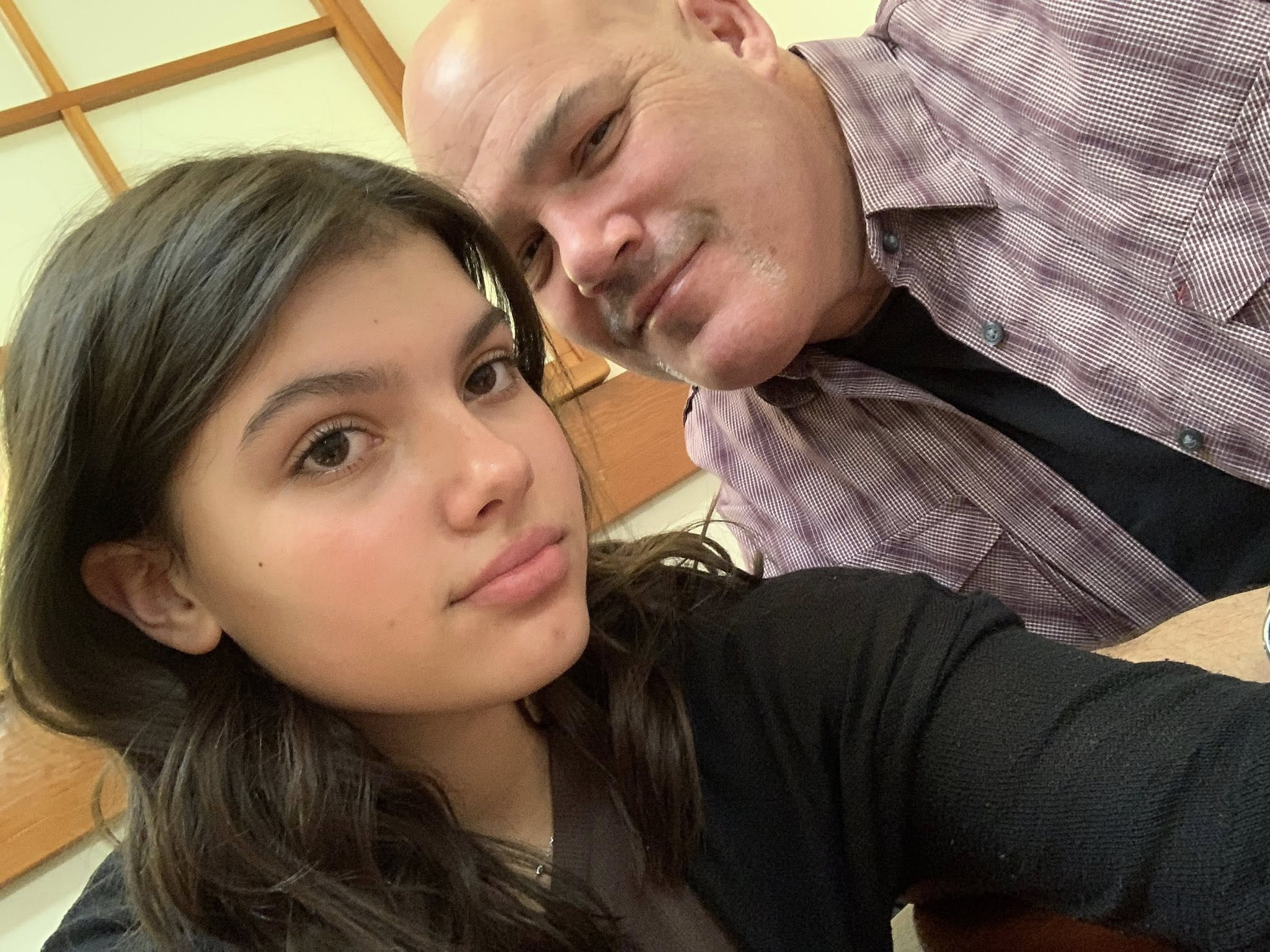 Um homem e uma mulher mais jovem, sua filha, numa fotografia posada.