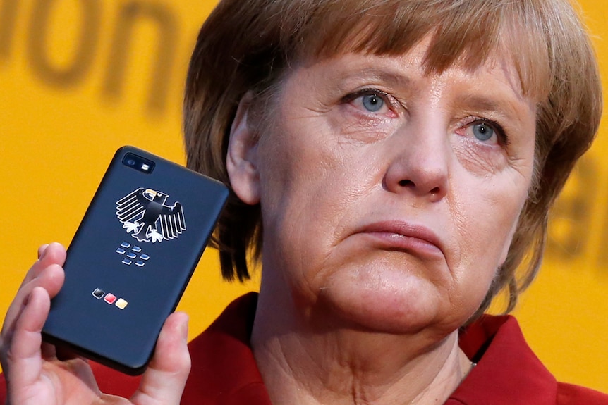  Angela Merkel holds a BlackBerry frowning. 