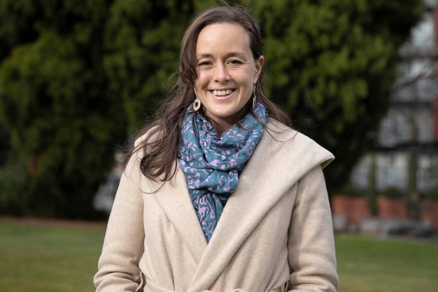 Woman wearing a coat looking forward.