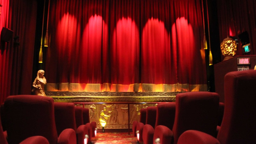 Cinema seats and bright red curtain over screen at Plaza Theatre, Laurieton.