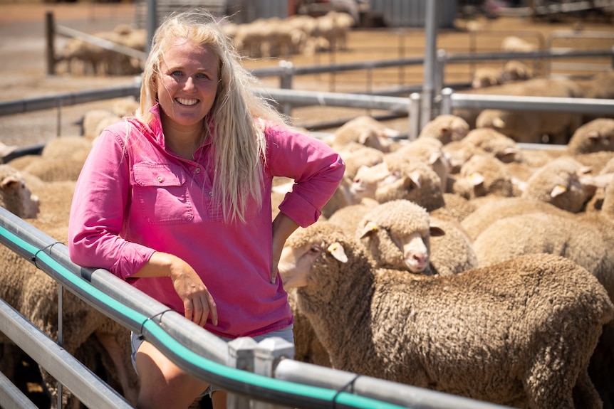 Photo of a woman smiling with sheep.